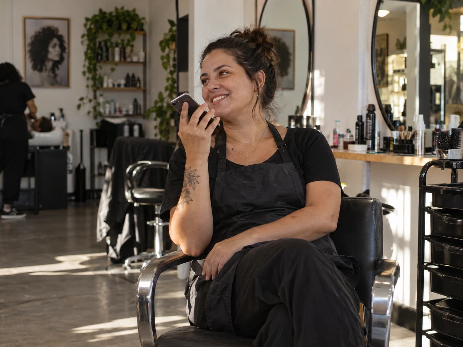 Dona de salão de beleza ouvindo uma mensagem de voz no celular e sorrindo